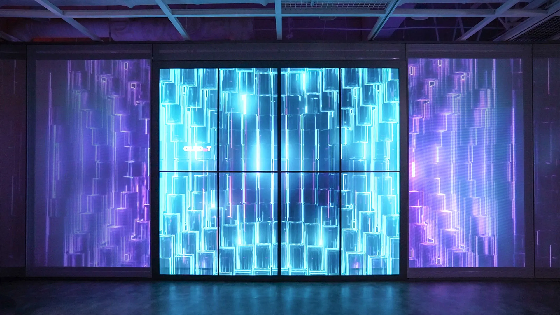 a dark room with large projection wall, blue and purple crystal refractive graphics on screen